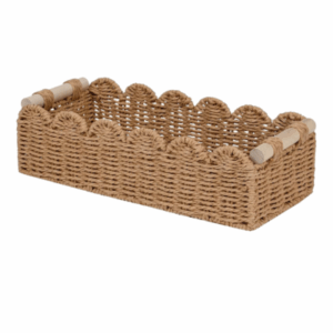 Rectangular woven wicker basket with scalloped edges and wooden handles on both sides, perfect for organizing essentials in a cozy guest room.