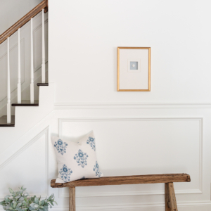 An entryway staircase with molding painted in Sherwin Williams Extra White.