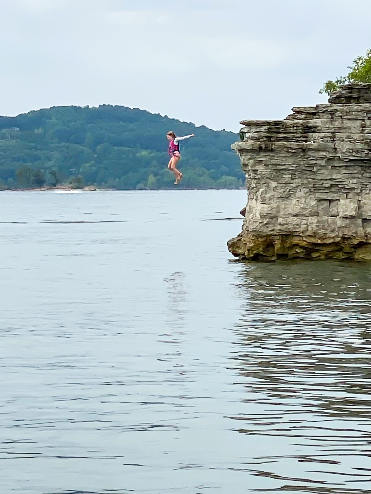 girl jumping off cliff on table rock lake
