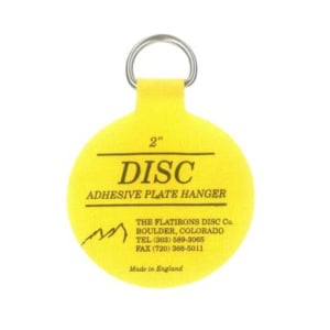 A yellow 2-inch adhesive plate hanger with a metal ring, perfect for securing your favorite plates. Labeled with product information and manufacturer contact details, these plate hangers offer both reliability and convenience.