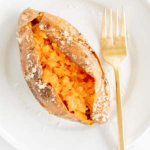A grilled sweet potato on a white plate.