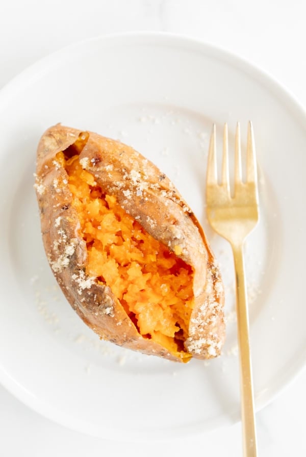 A grilled sweet potato on a white plate.