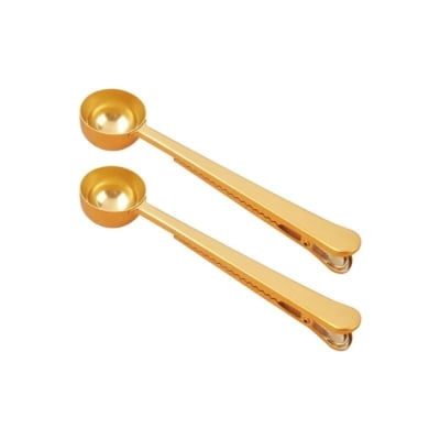 Two golden measuring spoons, essential kitchen gadgets, isolated on a white background.