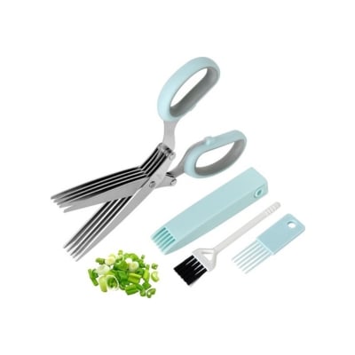 Herb scissors with cleaning comb and blade cover, a kitchen gadget accompanied by chopped herbs.