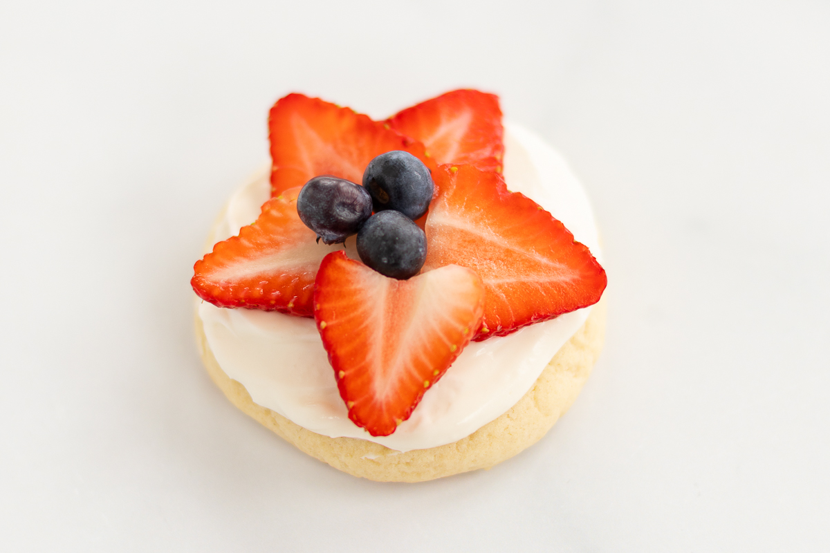 a frosted fruit pizza cookie with a star shape on top. 