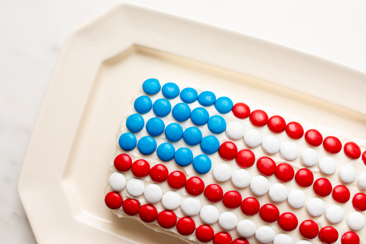 A red white and blue snack made of funfetti dip with patrioic m&ms on top.
