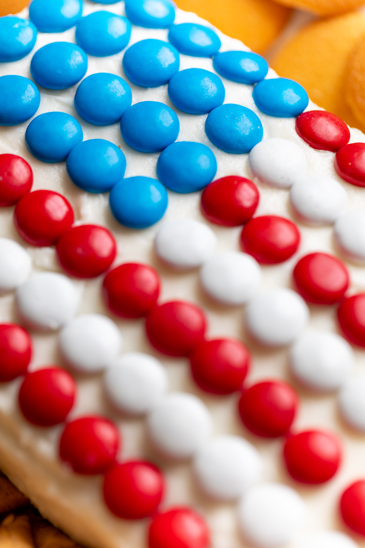 A red white and blue snack made of funfetti dip with patrioic m&ms on top.