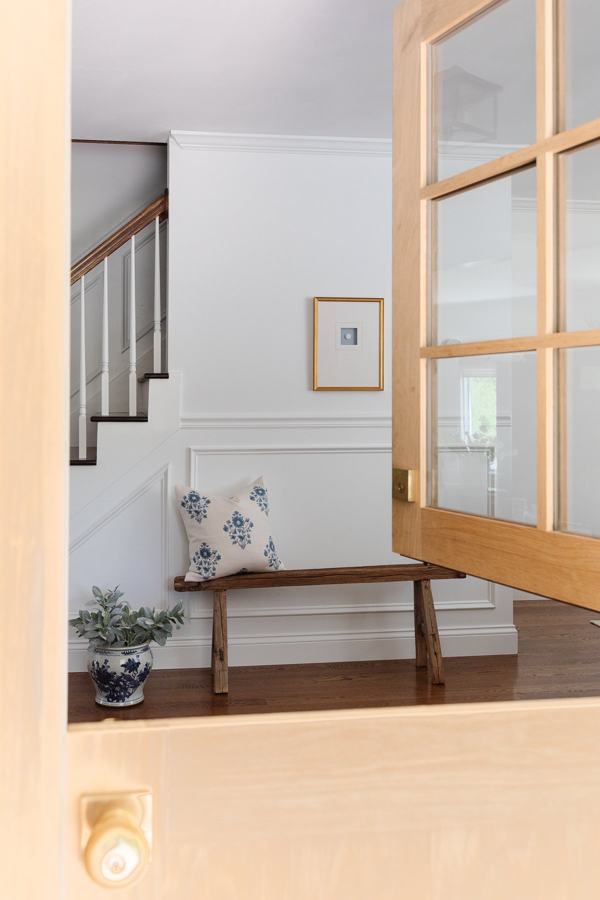 An entryway staircase with molding painted in Sherwin Williams Extra White. 