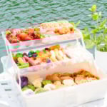 A snackle box on a white table with water in the background.