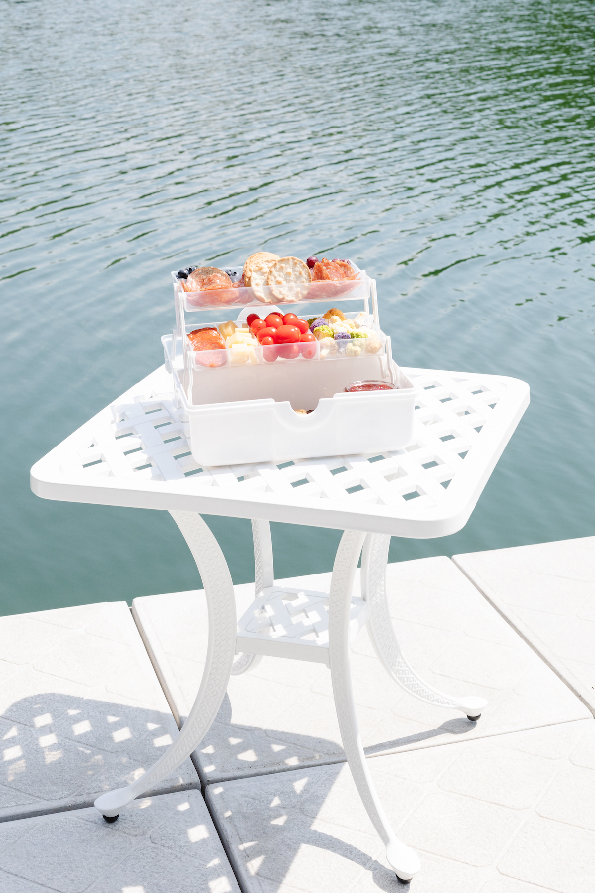A snackle box on a white table with water in the background. 