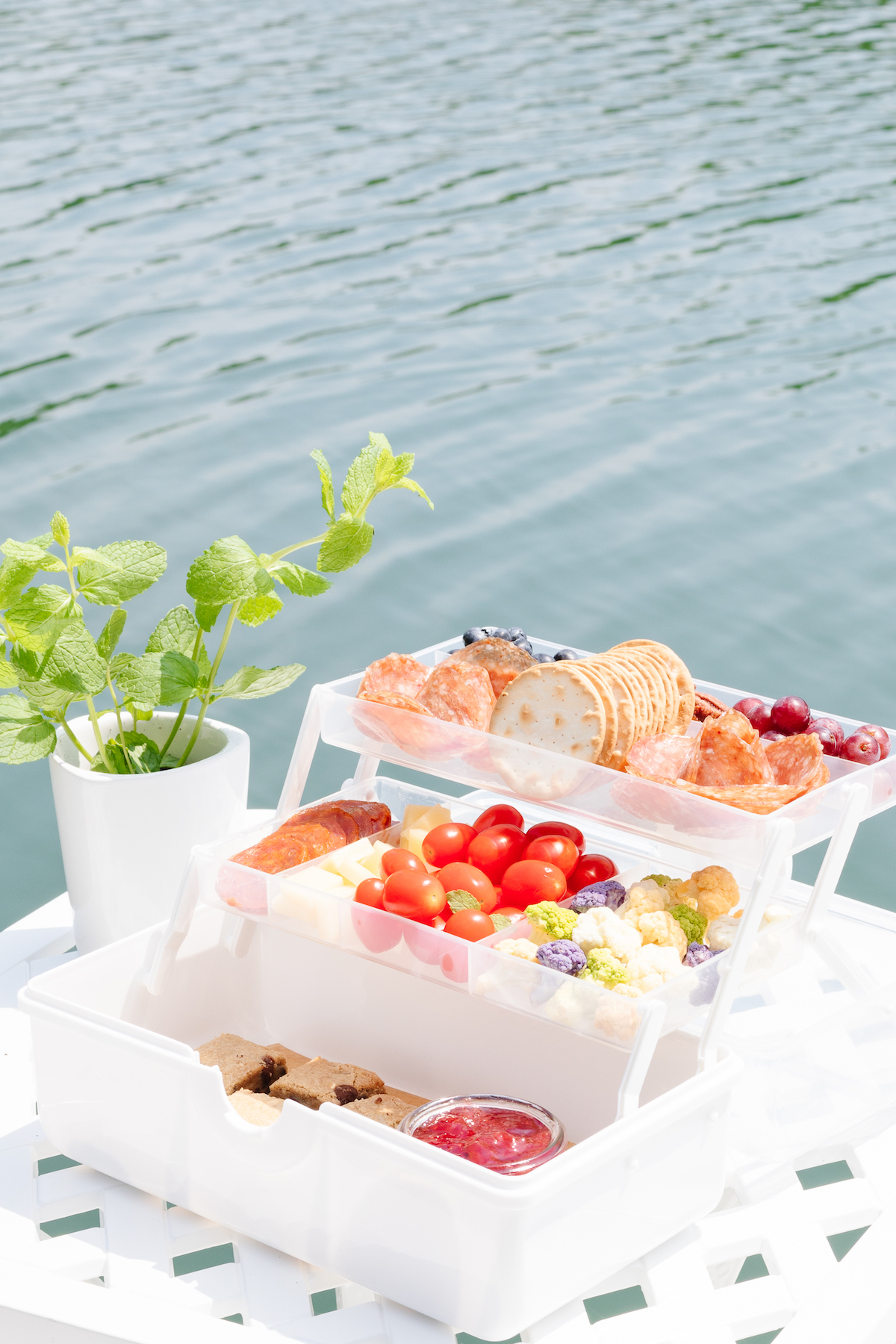 A snackle box on a white table with water in the background.
