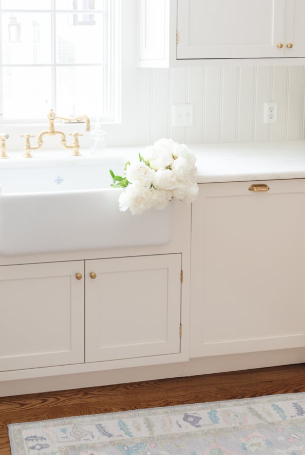 a farmhouse sink with white flowers in it