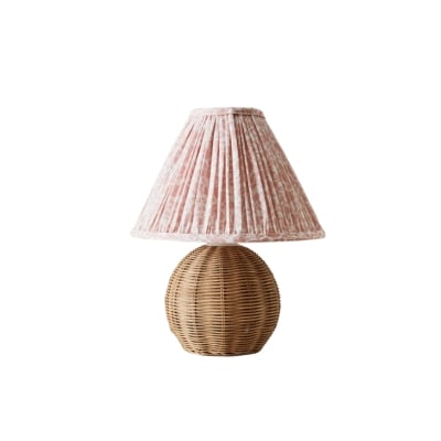 A rattan lamp with a floral pleated shade