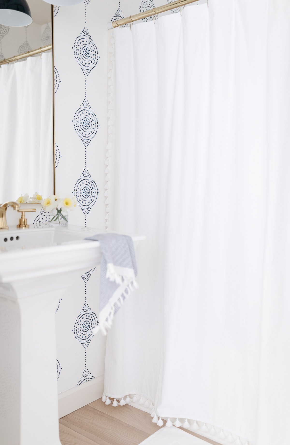 A bathroom with navy blue and white block print wallpaper.