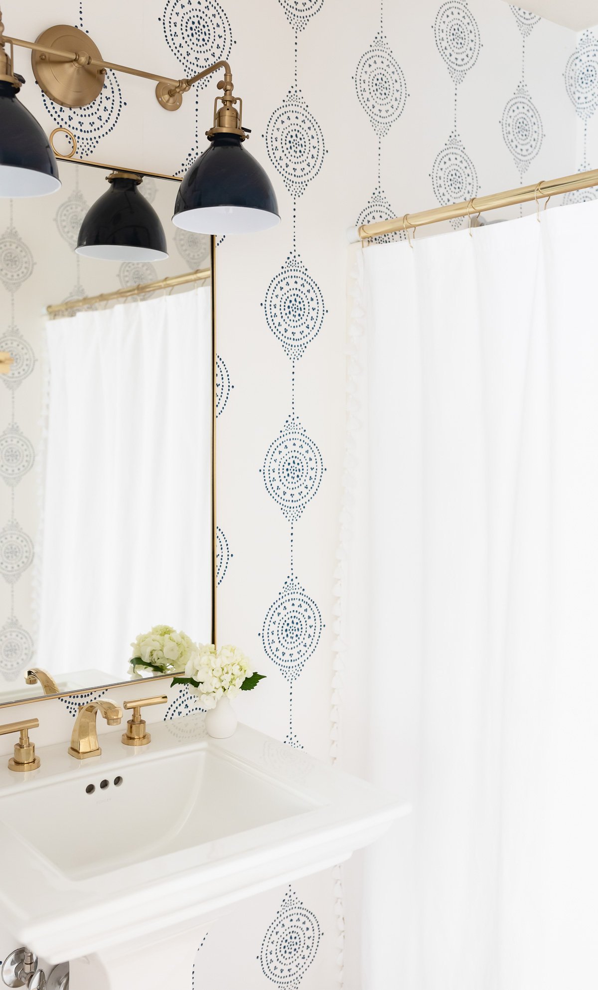 A bathroom with navy blue and white block print wallpaper.