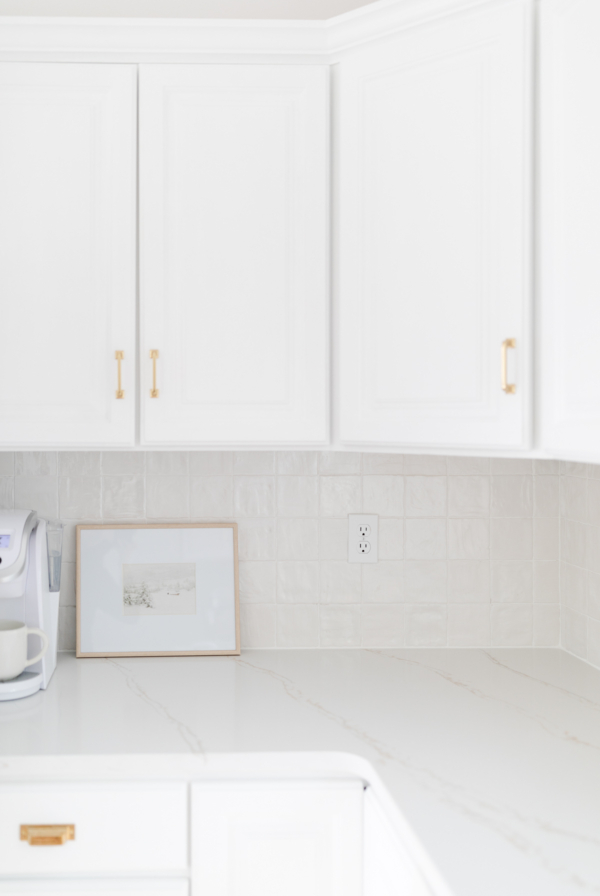 A white kitchen with a stacked tile backsplash.
