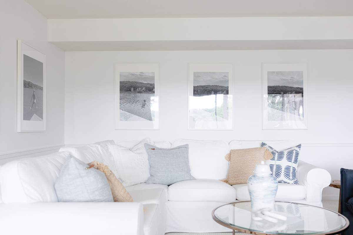 A white living room with a white sofa, decorated with pillows made from outdoor fabric