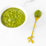 Walnut pesto in a white bowl on a marble countertop.