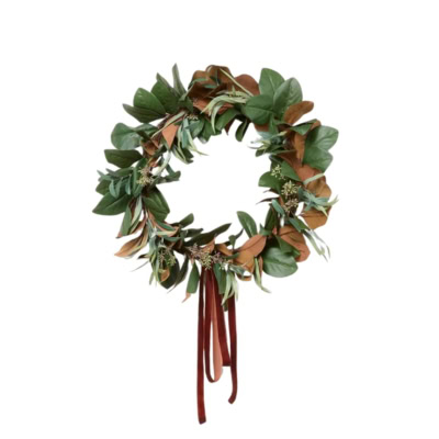 A green and brown fall wreath made of leaves, adorned with a red ribbon hanging from the bottom.