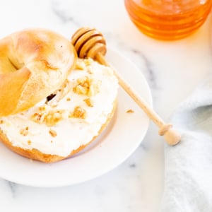 A bagel with honey walnut cream cheese on a plate.