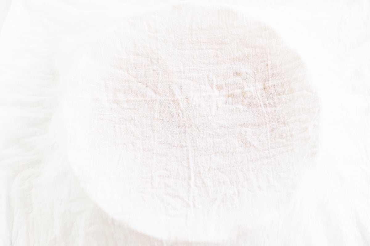 A close up of a white cloth on a white surface with Pumpkin Cinnamon Rolls.