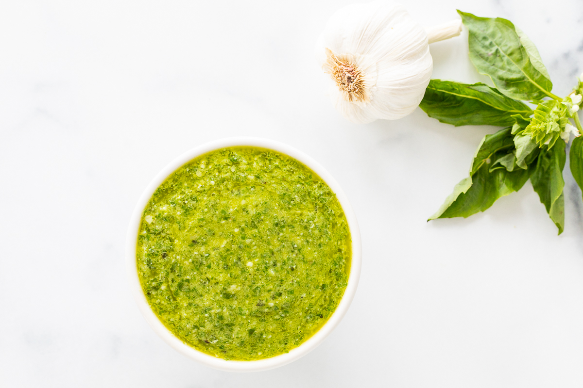 A bowl of nut-free pesto sauce with basil and garlic.