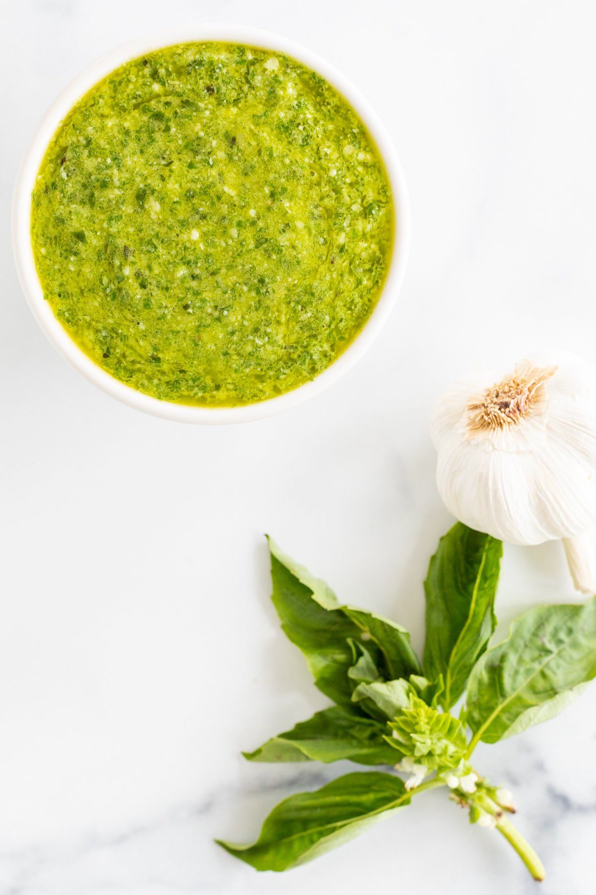 A bowl of nut-free pesto sauce with garlic and basil.
