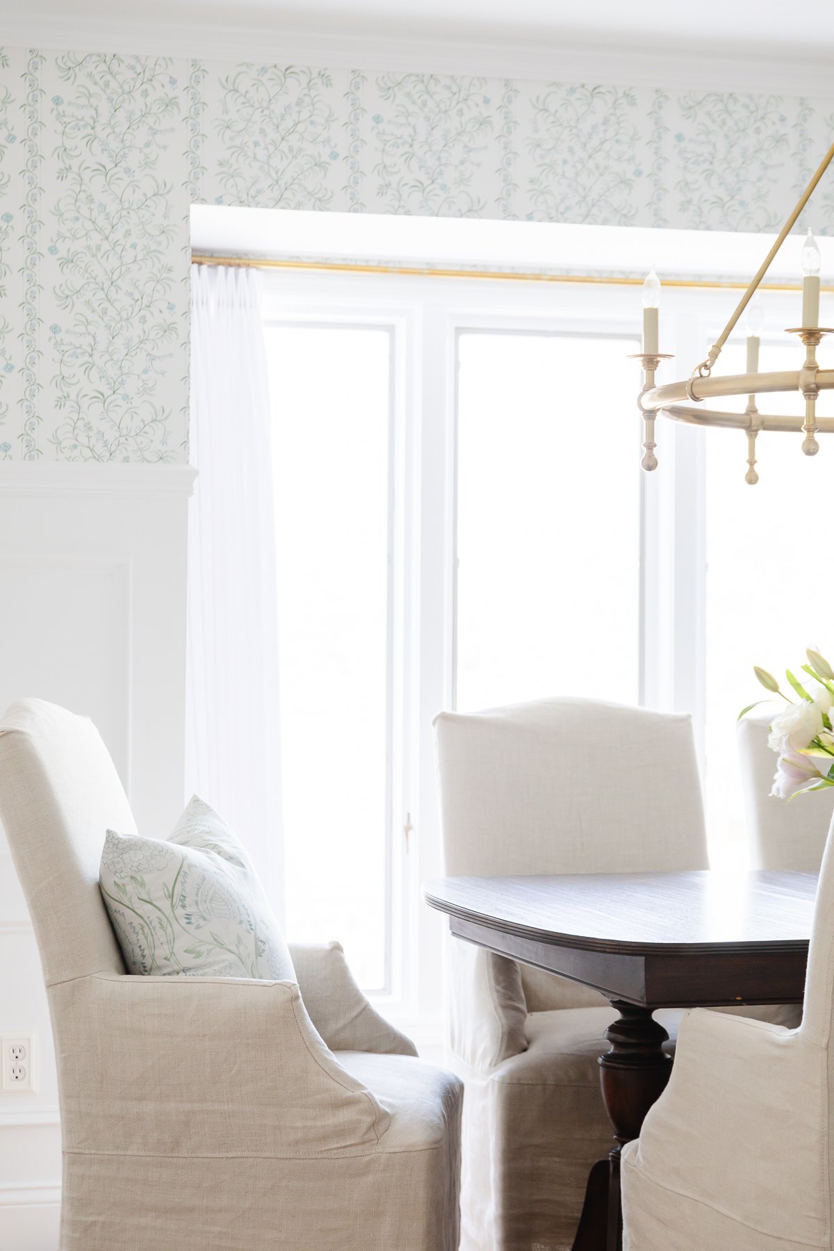 A dining room with pinch pleat drapes and a white table.