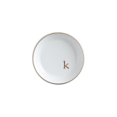 White ceramic plate with a gold rim and the letter 'k' in gold at the center. Ideal for adding an elegant touch to your table setting, this sophisticated piece is perfect for any occasion and could be a prime addition to your collection on Prime Day.