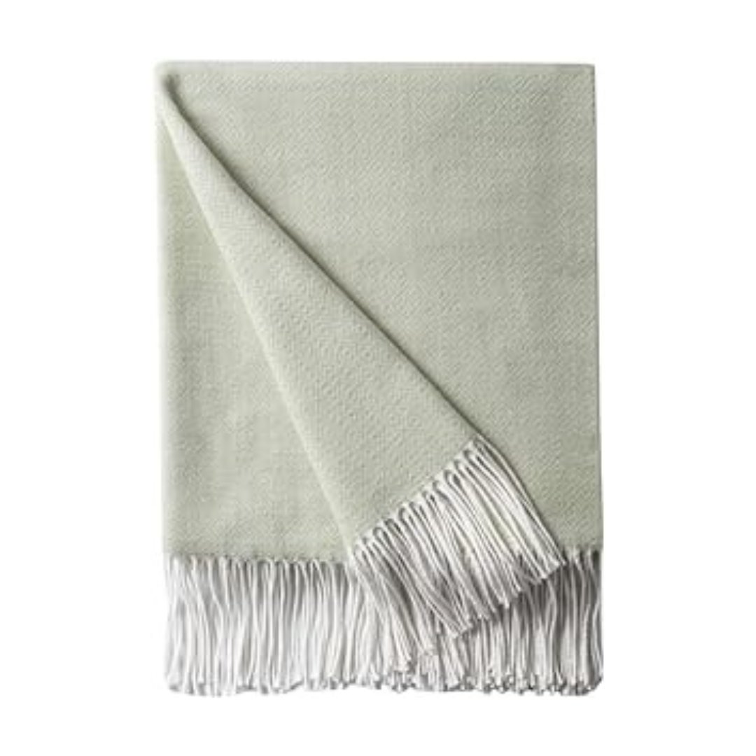 A light green throw with white fringes on Prime Day.