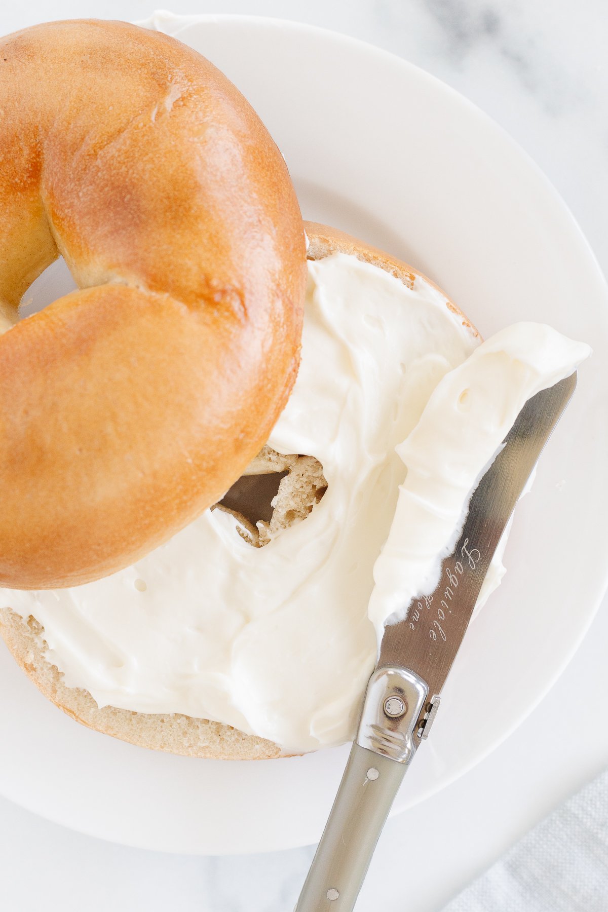 A bagel with whipped cream cheese spread.