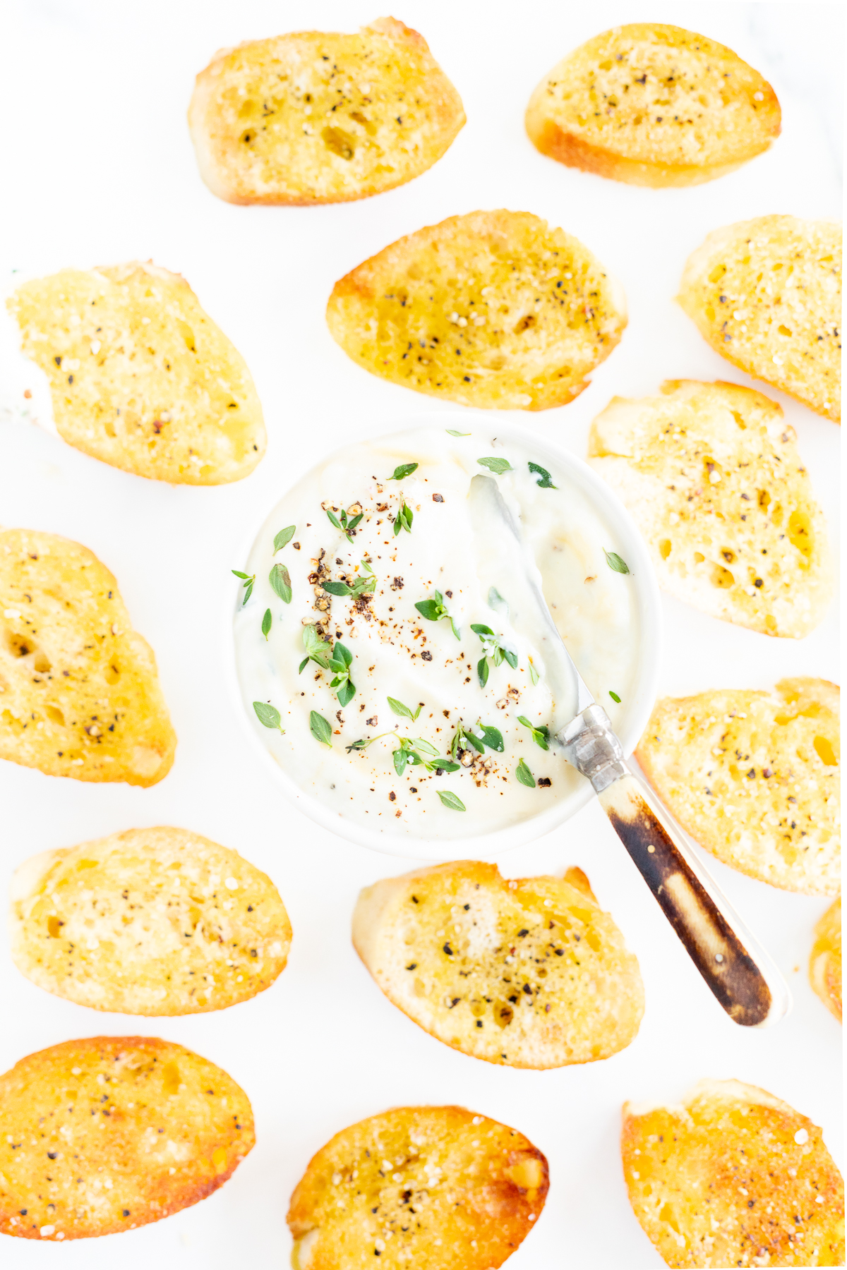 A bowl of whipped ricotta surrounded by crostini.