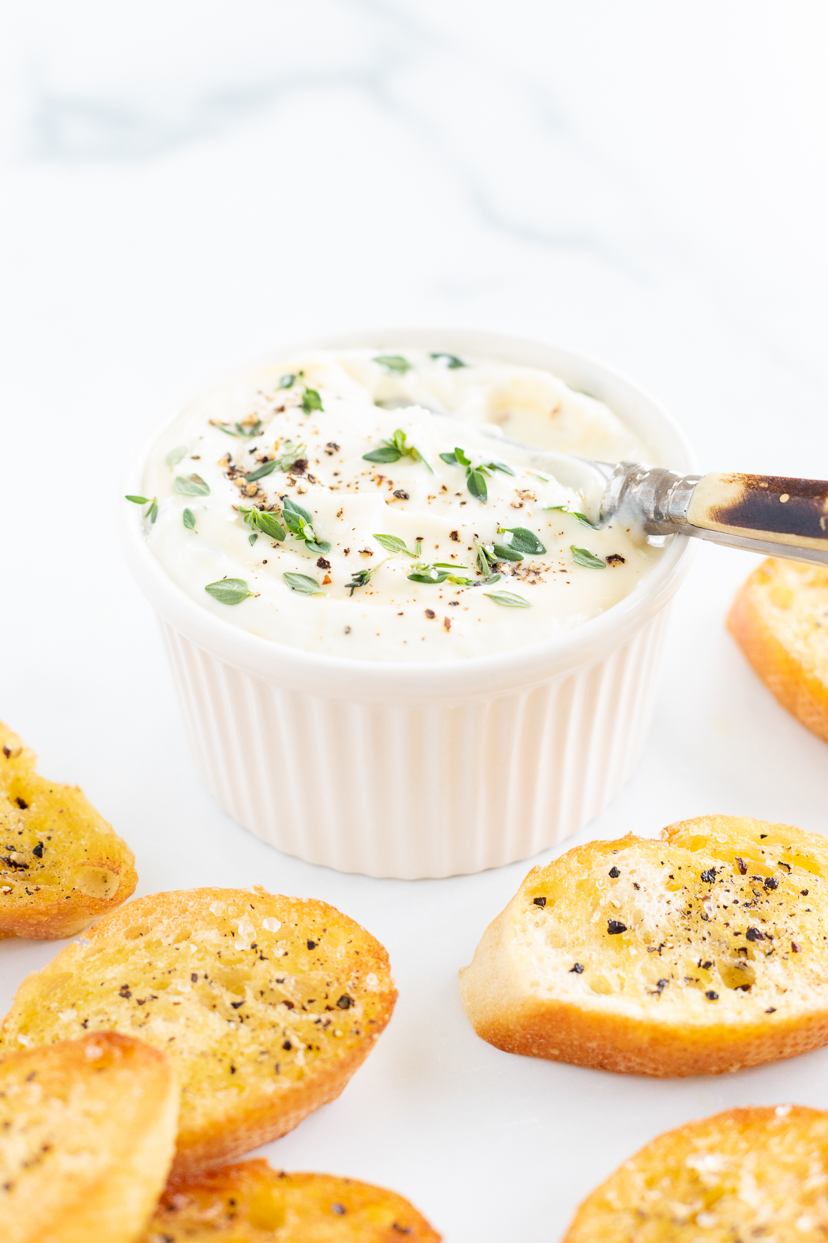 A bowl of whipped ricotta surrounded by crostini.