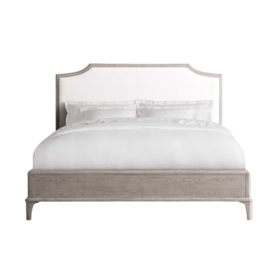 A bed with a white headboard and wooden frame, offering an affordable alternative to the high-end Arhaus look.