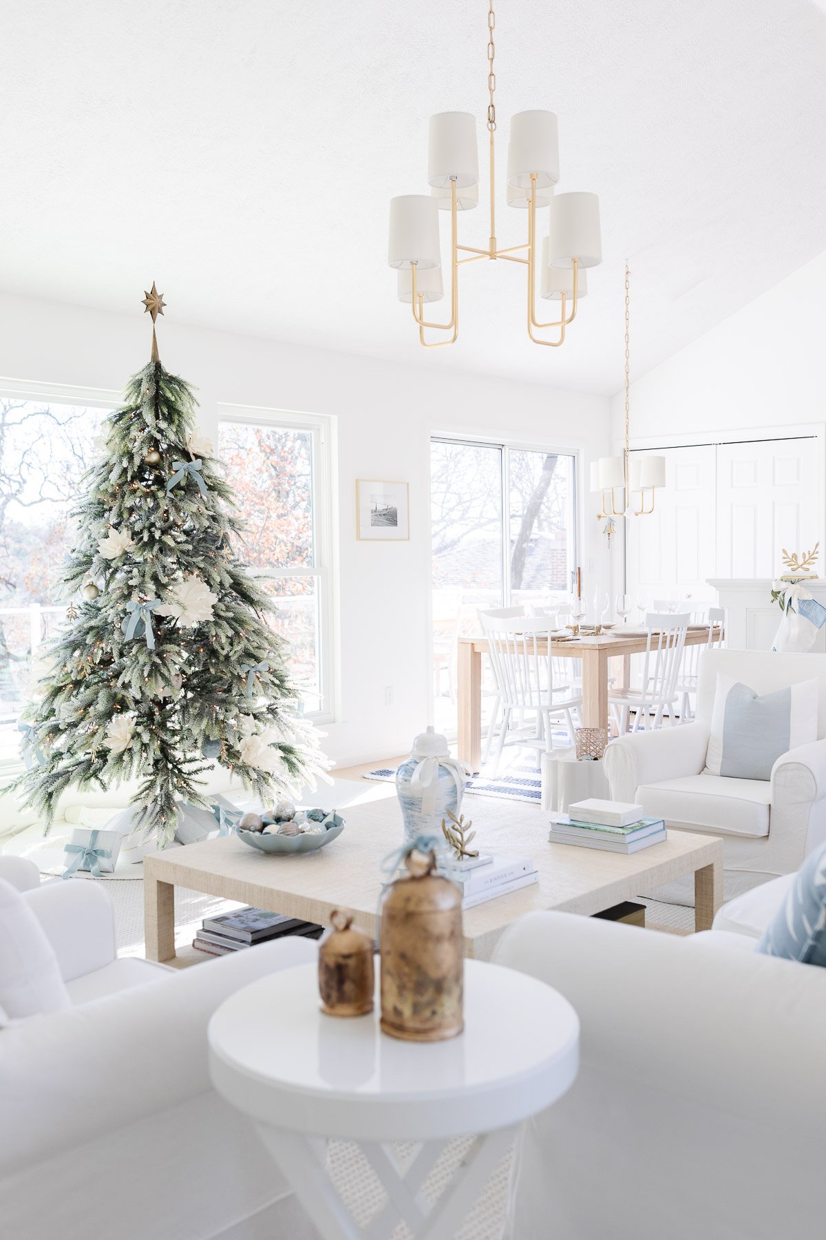 A white living room with a christmas tree.