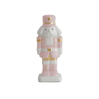 A pink nutcracker figurine among Christmas decorations on a white background.