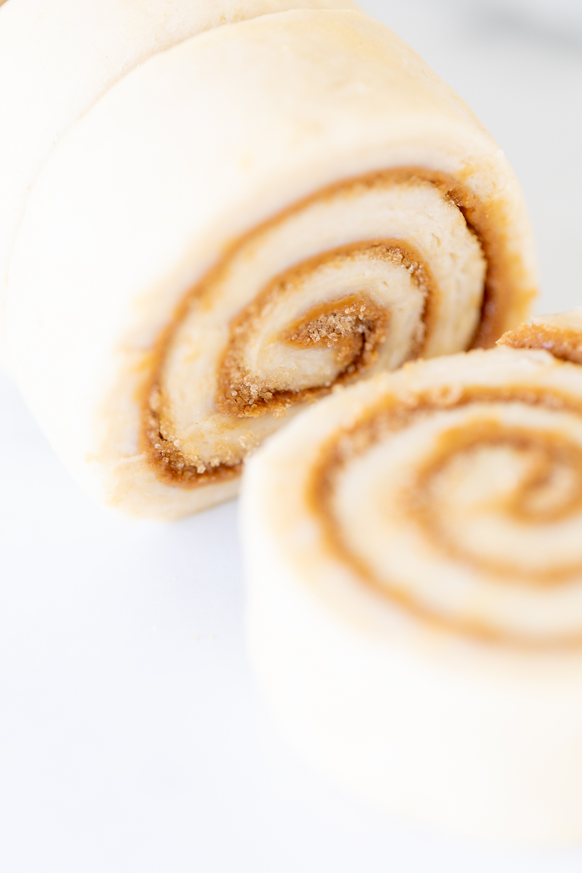 A slice of Cookie Butter Cinnamon Roll on a white surface.