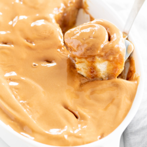 A person spreading Cookie Butter on a white dish.