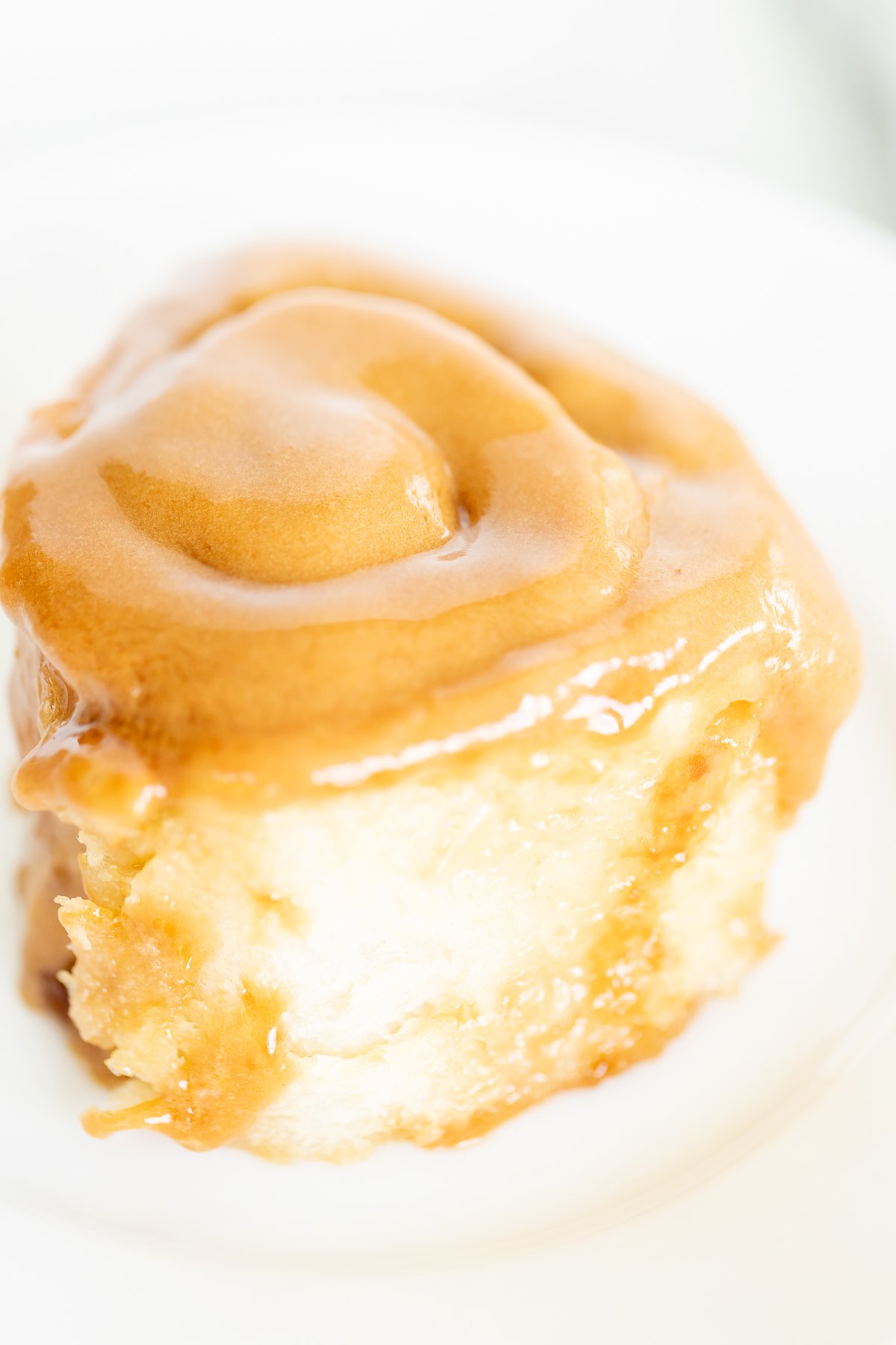 A Cookie Butter Cinnamon Roll on a plate, accompanied by a fork.