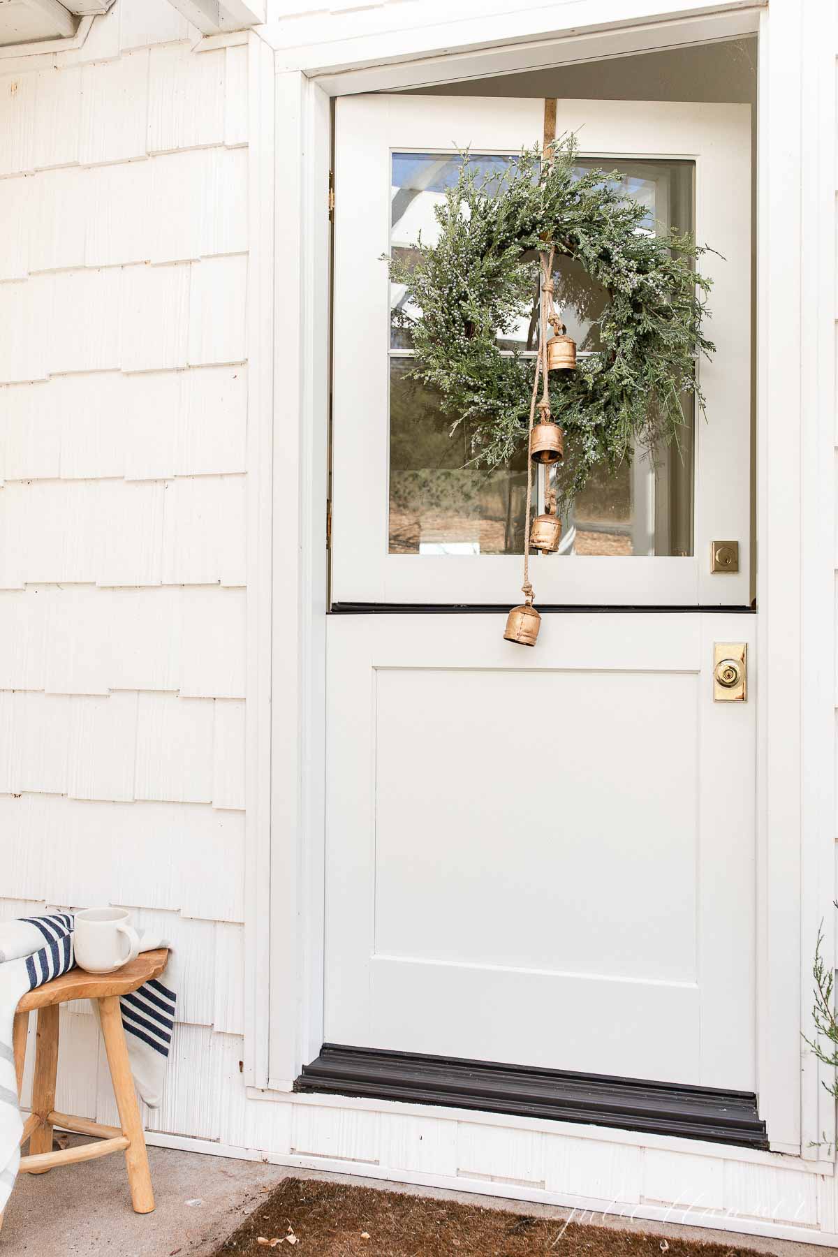 A white front door with a wreath on it.