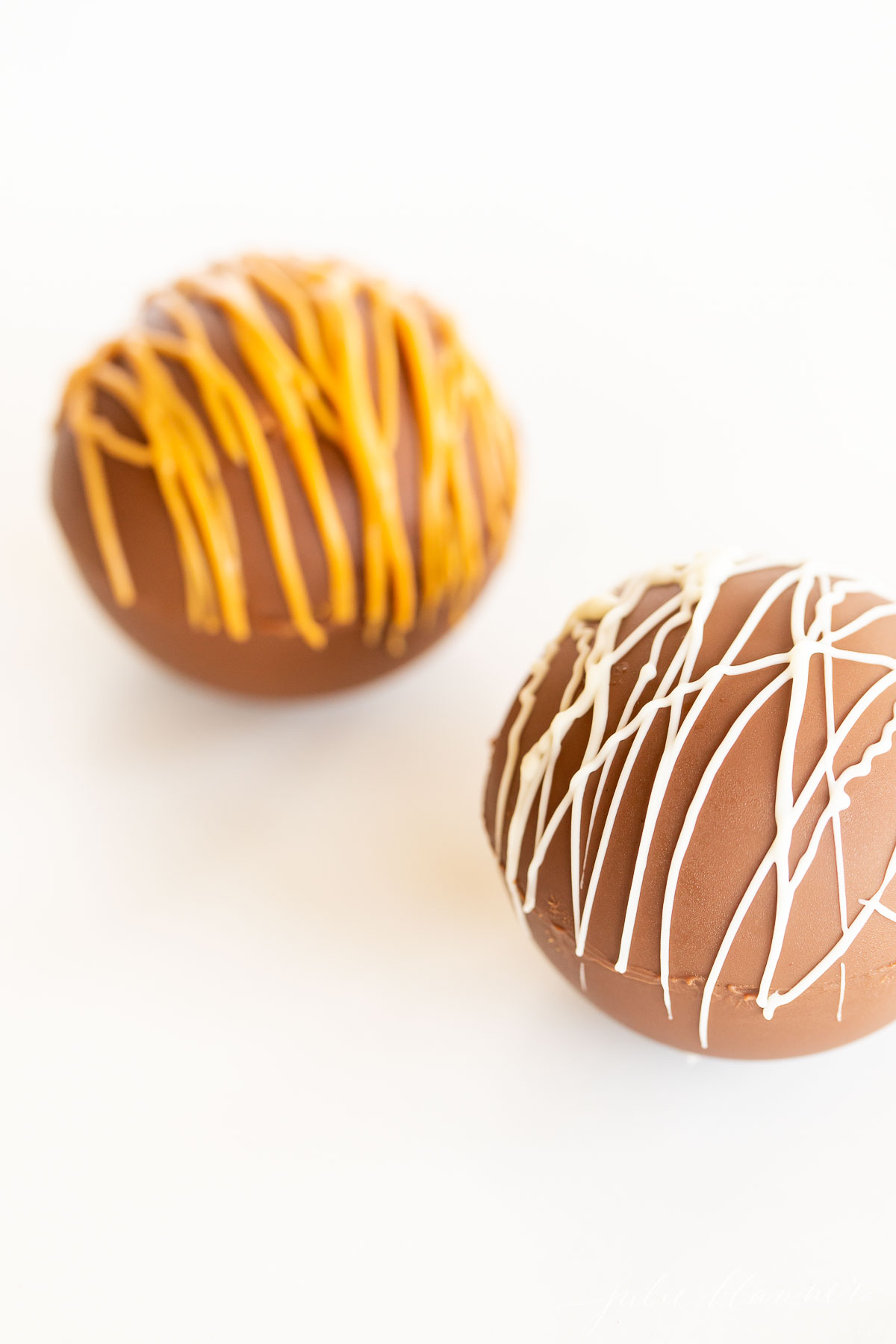 Two chocolate easter eggs with icing on them.