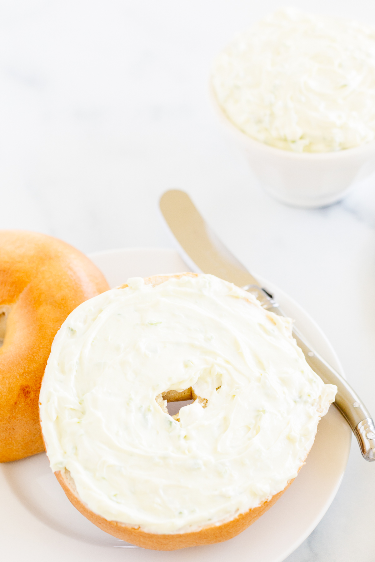 A jalapeño cream cheese bagel on a plate.