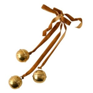 Three brass bells attached to brown ribbons tied in a bow.