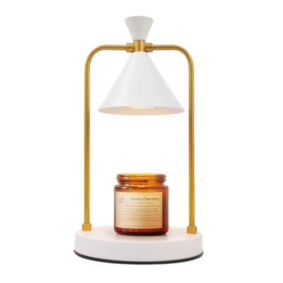 A white and gold lamp with a candle on it.