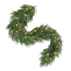 Artificial norfolk pine garland decorated with small, warm white string lights, arranged in a serpentine shape on a white background.