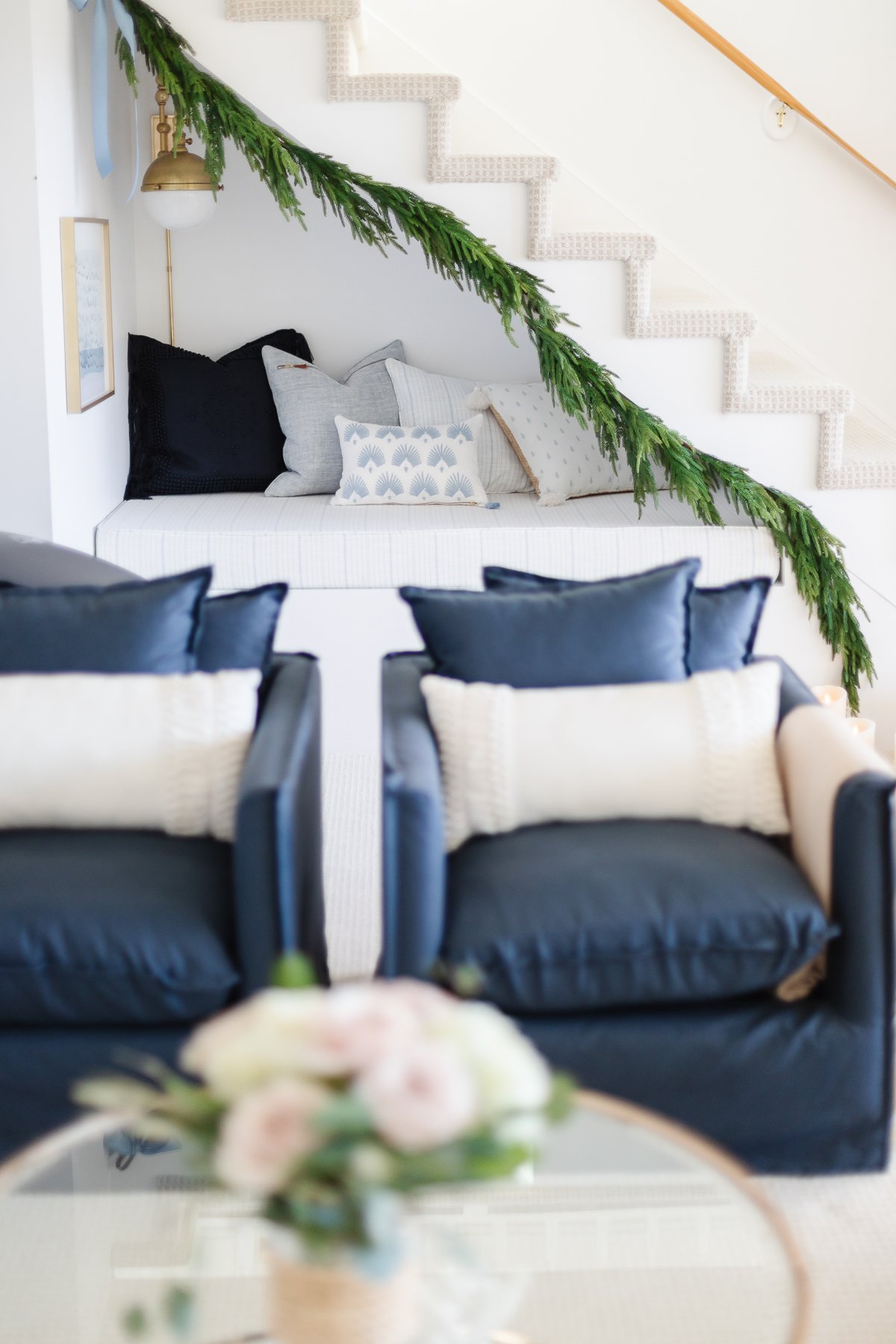 A living room with blue chairs and a christmas garland.