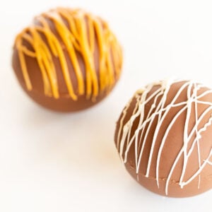 Two peanut butter chocolate easter eggs with icing on them.
