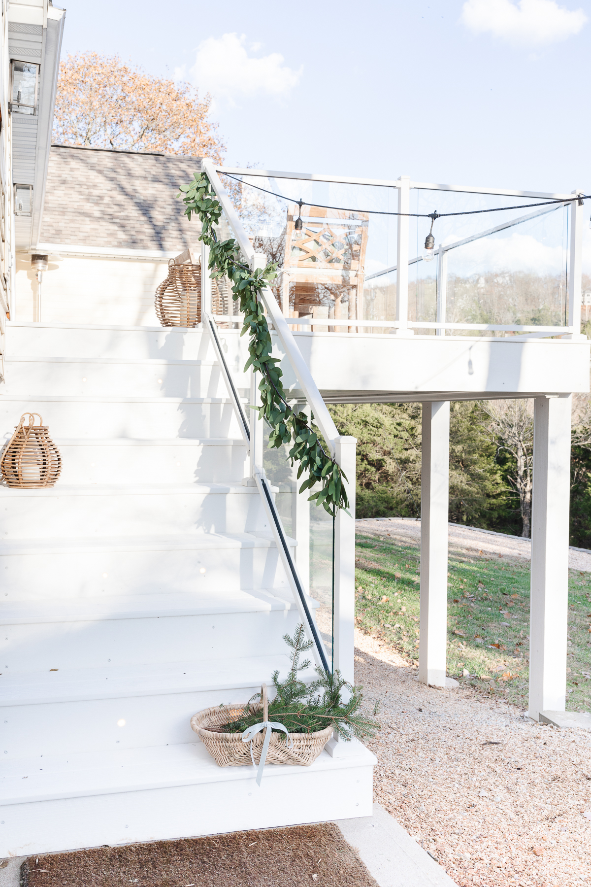 A white stairway with eucalyptus garland and baskets on it.