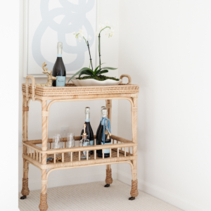 A rattan bar cart adorned with wine bottles on Cyber Monday.