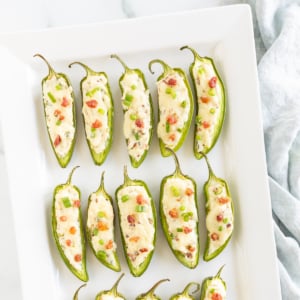 Stuffed jalapeno peppers on a white plate.